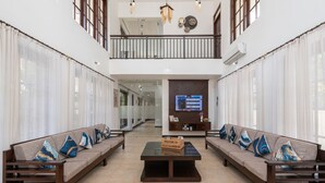 Amplia sala de estar con techo alto, una mesa de centro y dos sofás con cojines decorativos.