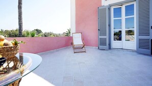 A patio with a table, a wicker basket with fruits, and a blank easel. - Antica Dimora La Portazza (Marsala)