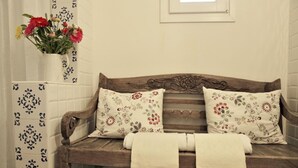 A wooden bench with floral cushions and a white towel, set against a tiled wall with a decorative pattern. - Antica Dimora La Portazza (Marsala)