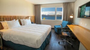 A hotel room with a bed, a desk, a chair, a window with a view, and a mounted TV. - Hampton by Hilton Bariloche (San Carlos de Bariloche)