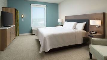 A hotel room with a bed, bedside tables, a TV, a window, and a view of the city.