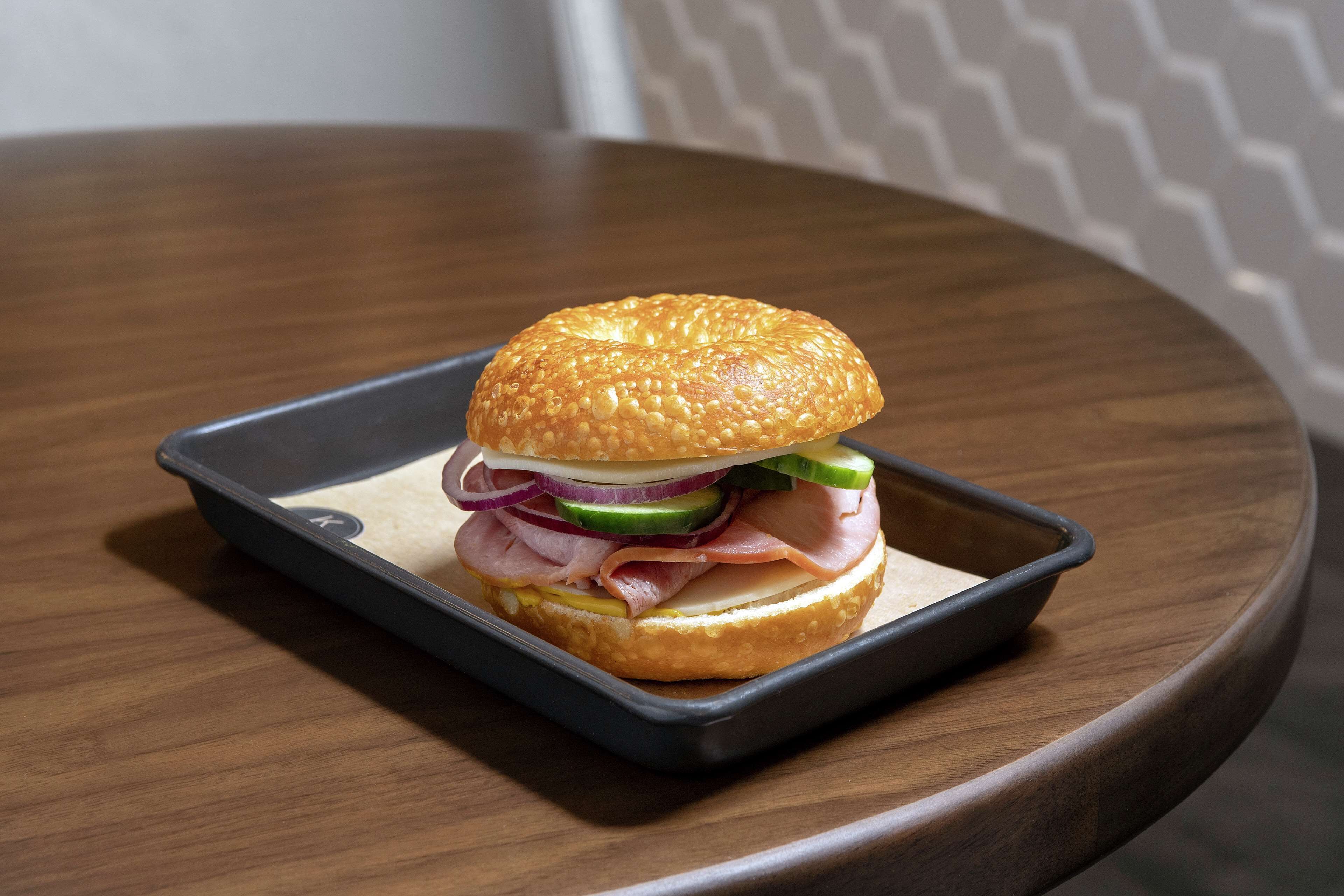 Un sandwich sur un plateau, posé sur une table ronde.