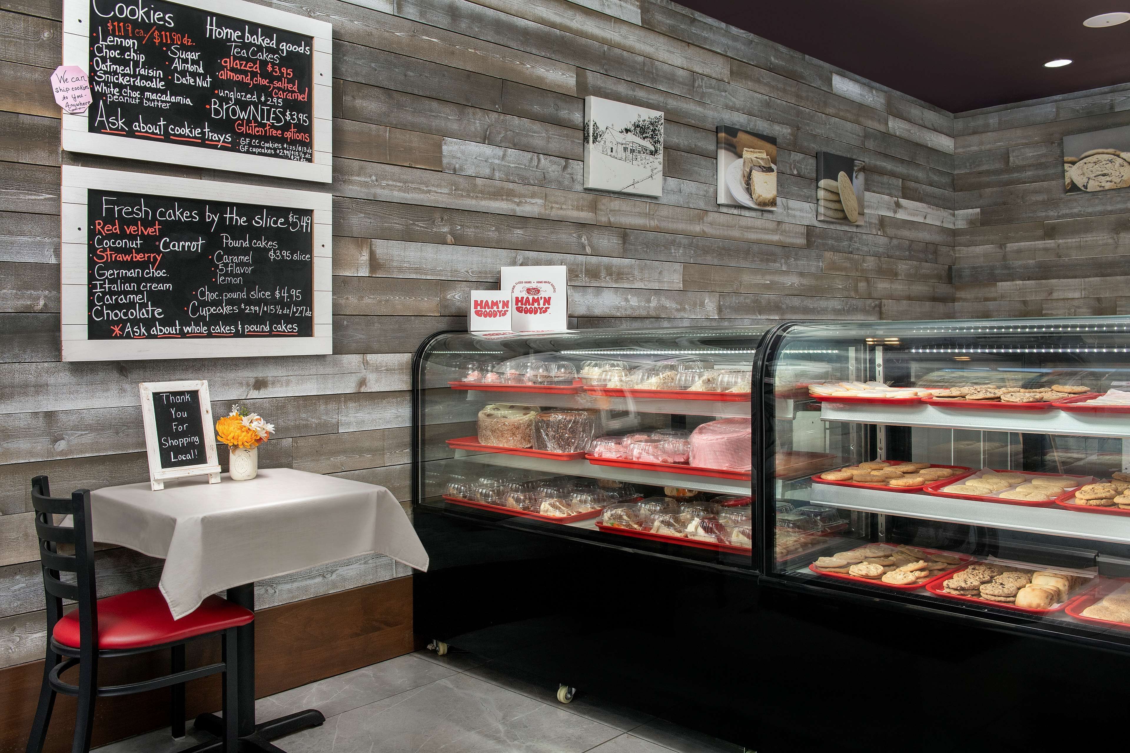 A bakery display with various baked goods and a chalkboard menu listing items like cookies and cakes.