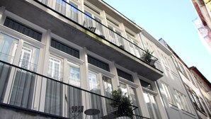 Un immeuble à plusieurs étages, doté de balcons, de grandes fenêtres et surplombant un ciel dégagé.