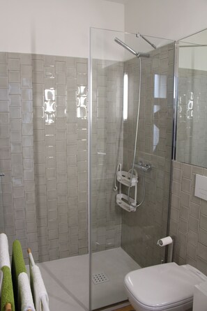 Een douche, handdoeken, zeep, shampoo