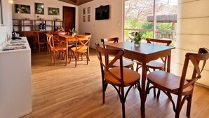 A spacious dining area with wooden furniture and a large window offering a view of the outdoors. - Pousada Solar do Pico (Fernando de Noronha)