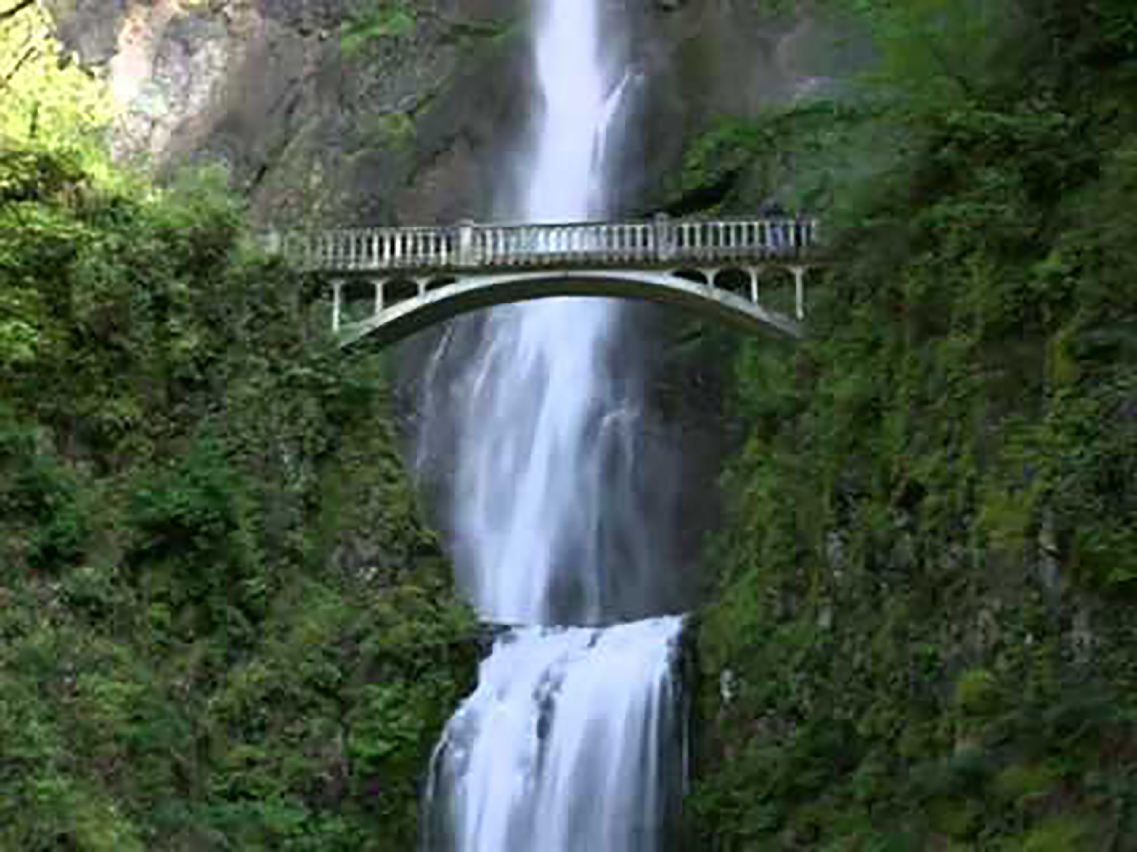 A waterfall with a bridge over it.