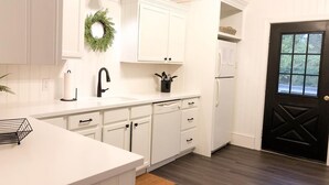 A kitchen with white cabinetry, a black door, and a window. - 2 Blocks to Mall - 8 Minute Walk to Beach (Cape May)