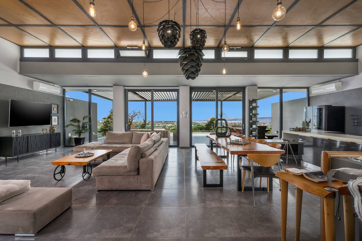 A spacious living area with a large sofa, dining table, and kitchen area.