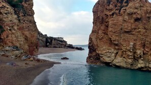 A coastal landscape with rocky cliffs and a sandy beach. - Nice and cozy house in Peratallada (Peratallada)