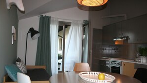 Un espace de vie compact comprenant un coin repas, une kitchenette et un lit avec des oreillers.