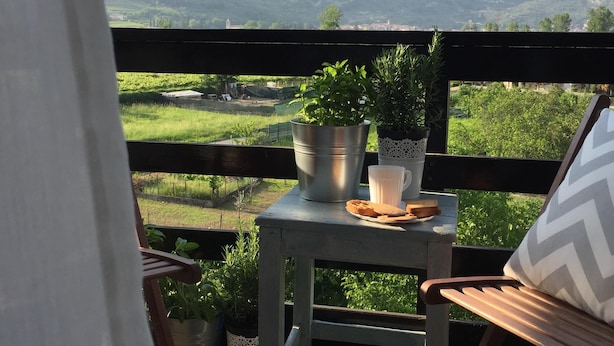 Un balcon avec une table, une chaise et une vue sur les montagnes.