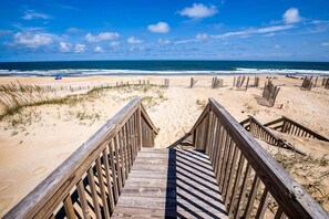 Eine Holzpromenade führt zu einem Strand mit freiem Blick auf den Ozean.