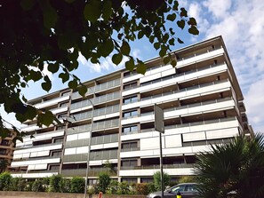 Un edificio a più piani con un design architettonico moderno, caratterizzato da balconi e ampie finestre.