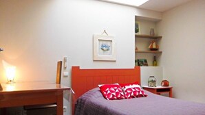 A bedroom with a bed, a desk, and a chair. There is a shelf with various items and a framed picture on the wall. - HOUSE 4/5 PEOPLE LA ROCHELLE (La Rochelle)
