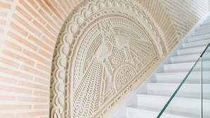 Un escalier orné de sculptures complexes et doté d’une rampe en verre.