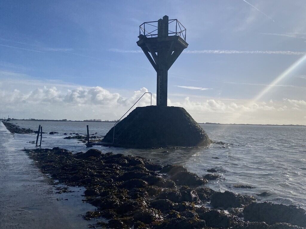 Ett fyrtorn på en klippig udde med fri sikt över havet och en avlägsen kustlinje.