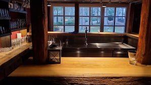 Una cocina rústica con un ventanal grande, repisas de madera y una encimera de madera.