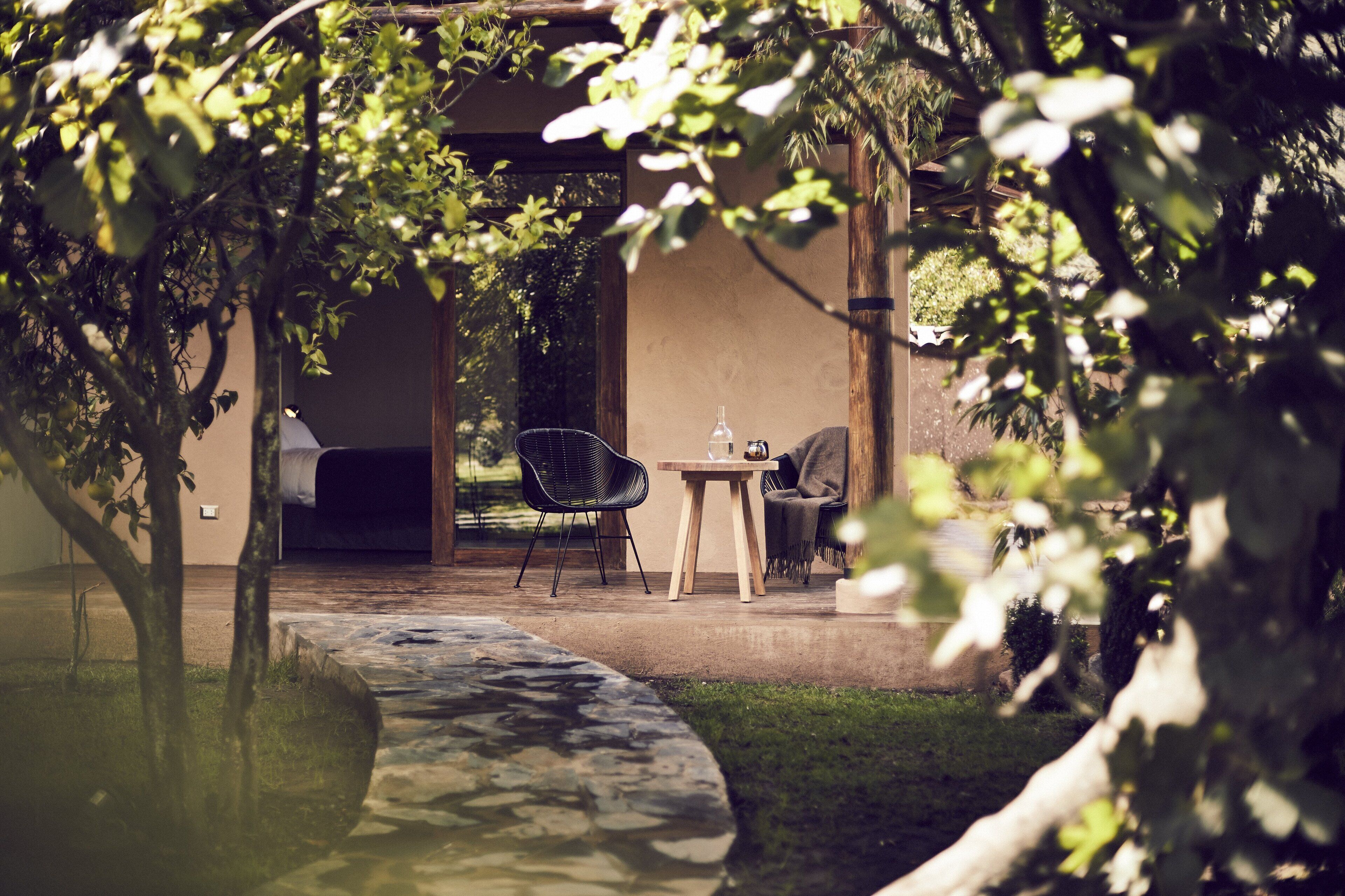 A patio area with a table and chairs, a small water feature, and a covered seating area.
