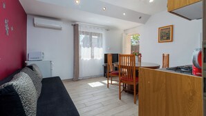 Eine kompakte Küche mit Essbereich, einer Couch und einem Fernseher.