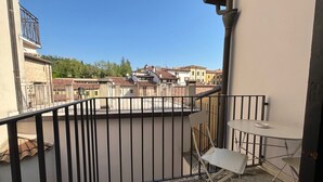 A balcony with a view of buildings, a table, and two chairs. - Rivadige Suite 4 with beautiful view on the river (Verona)