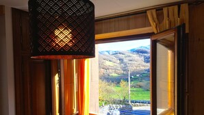 Une pièce dotée d’une grande fenêtre, de murs en bois et d’un luminaire suspendu.