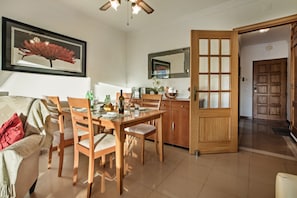 A dining area with a wooden table, chairs, and a large mirror above it.