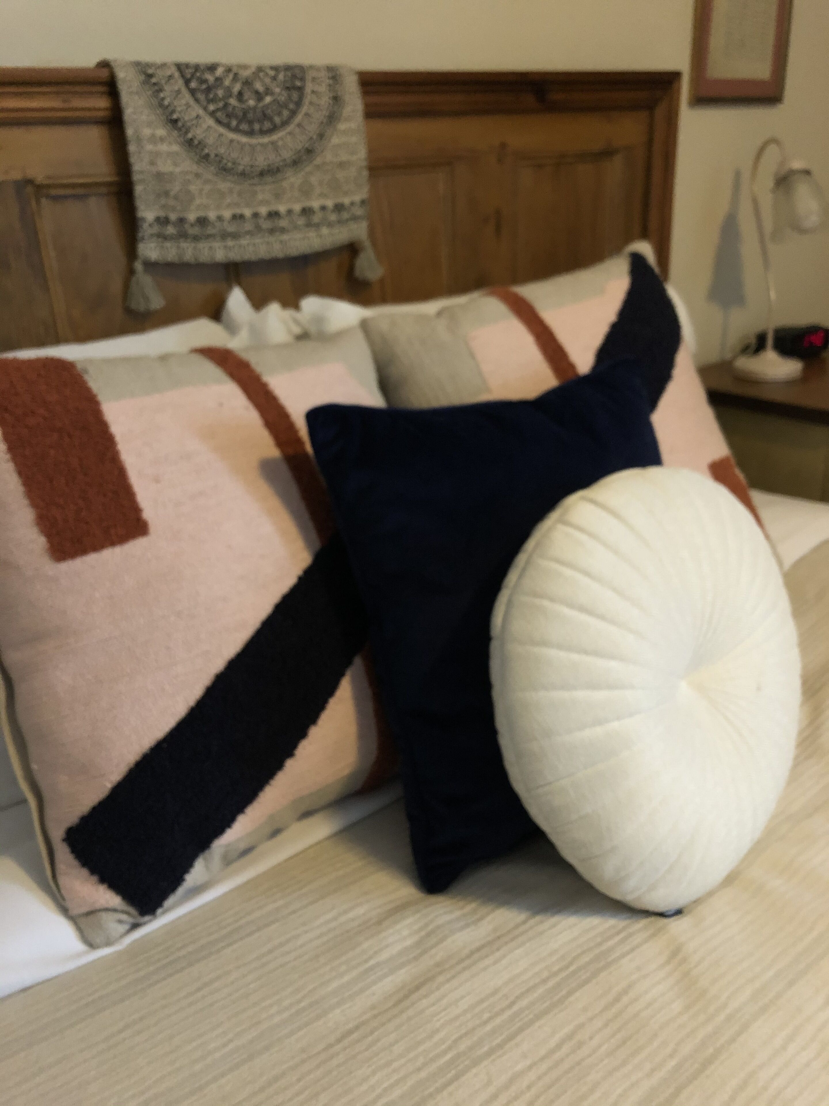 A bed with a patterned blanket and multiple pillows.