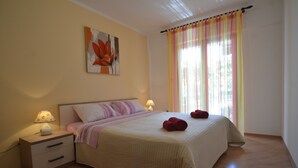 A bedroom with a bed, nightstand, lamp, and artwork on the wall. - Apartment Kuftic - Relax Zone (Rovinj)