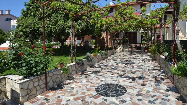 A tiled pathway leading to a building with a pergola covered in vines. - Apartment Kuftic - Relax Zone (Rovinj)