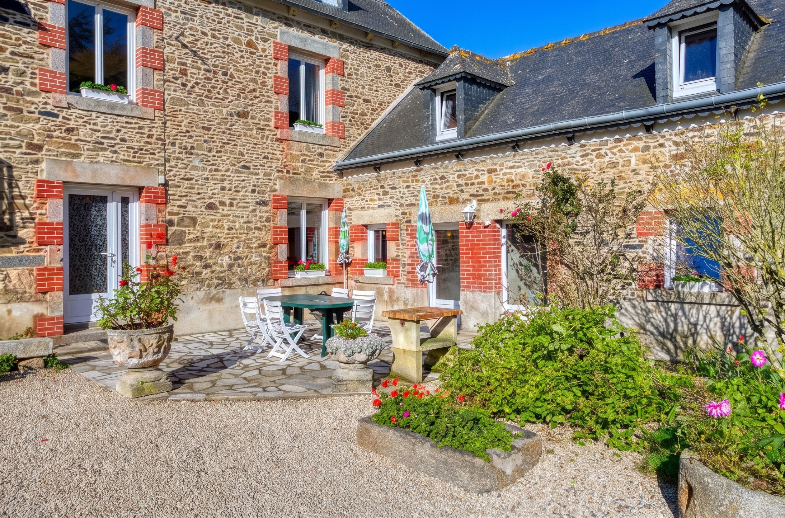 A stone building with a courtyard, outdoor seating, and a flag.