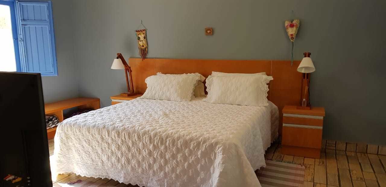 Un dormitorio con una cama grande, dos mesitas de noche y un televisor montado en la pared.