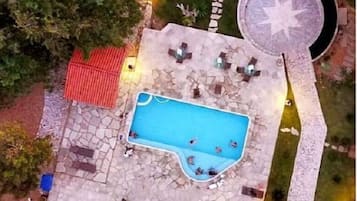 Relax by the resort's rectangular pool surrounded by a patio and lush greenery.