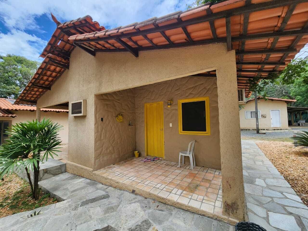 A building with a tiled roof, a yellow door, and a small outdoor seating area.
