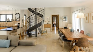 A spacious living area with a spiral staircase, a dining table, and a cozy seating area. - Bastide Blanche: Villa with swimming pool and pétanque court in Lourmarin. (lourmarin)