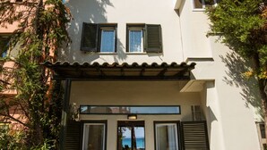 Une maison à deux étages avec un balcon, une porte et une vue sur la mer.