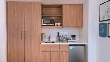 A kitchen with wooden cabinets, a microwave, a sink, and a dishwasher.