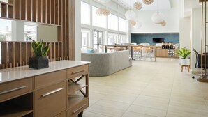 Una cocina moderna con una isla central, ventanas amplias e iluminación colgante.