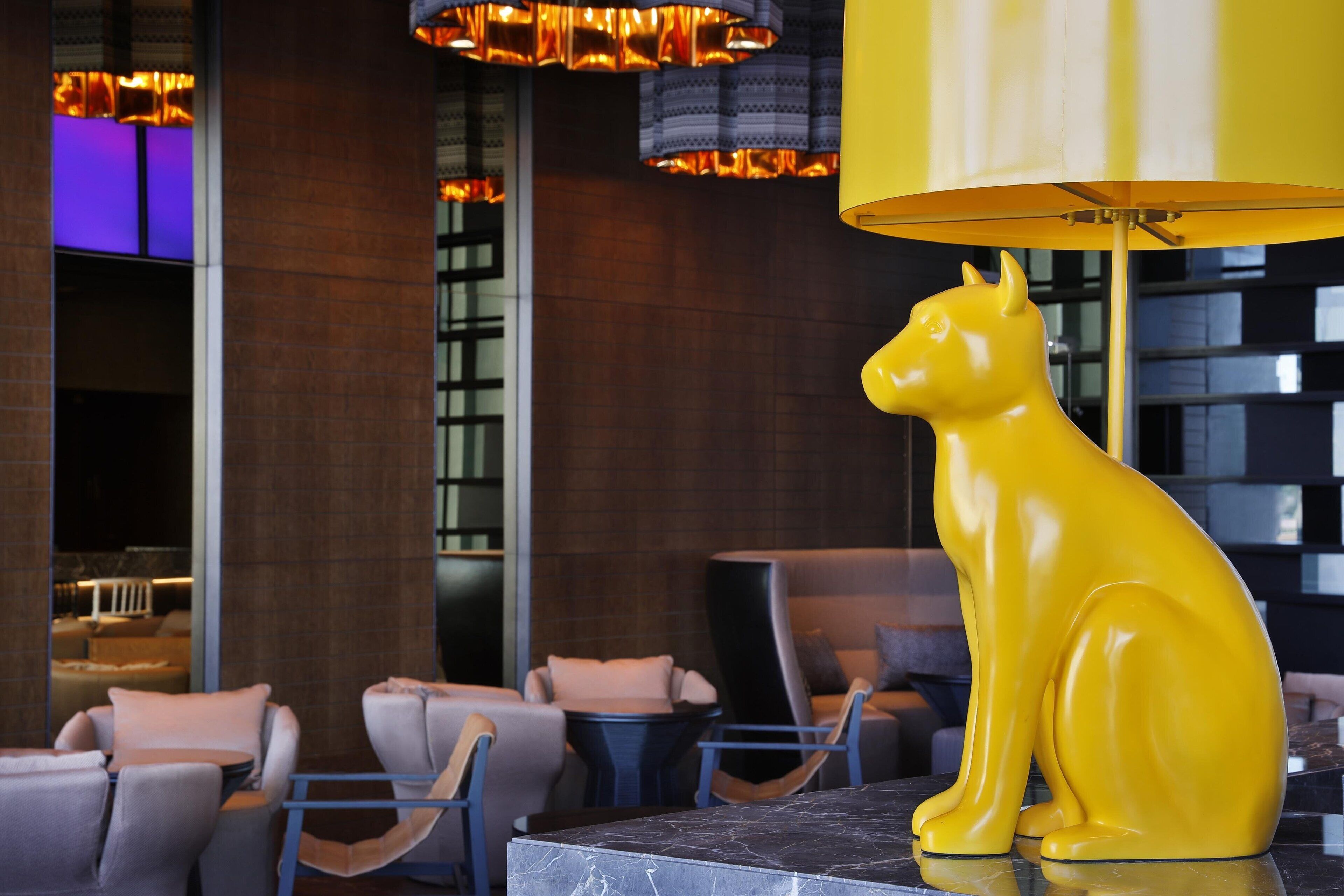 Un intérieur moderne agrémenté d’une sculpture jaune, d’un espace salon et d’un éclairage contemporain.