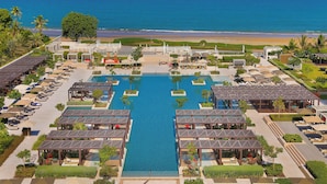 A resort with a central pool, multiple lounge areas, and a beach view. - W Muscat (Muscat)