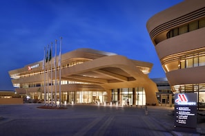 A Marriott hotel with a modern architectural design, featuring a prominent entrance and multiple flags.