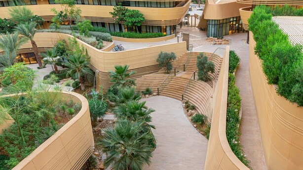 A modern building with curved architecture, landscaped courtyards, and a central pathway. - Marriott Riyadh Diplomatic Quarter (Riyadh)