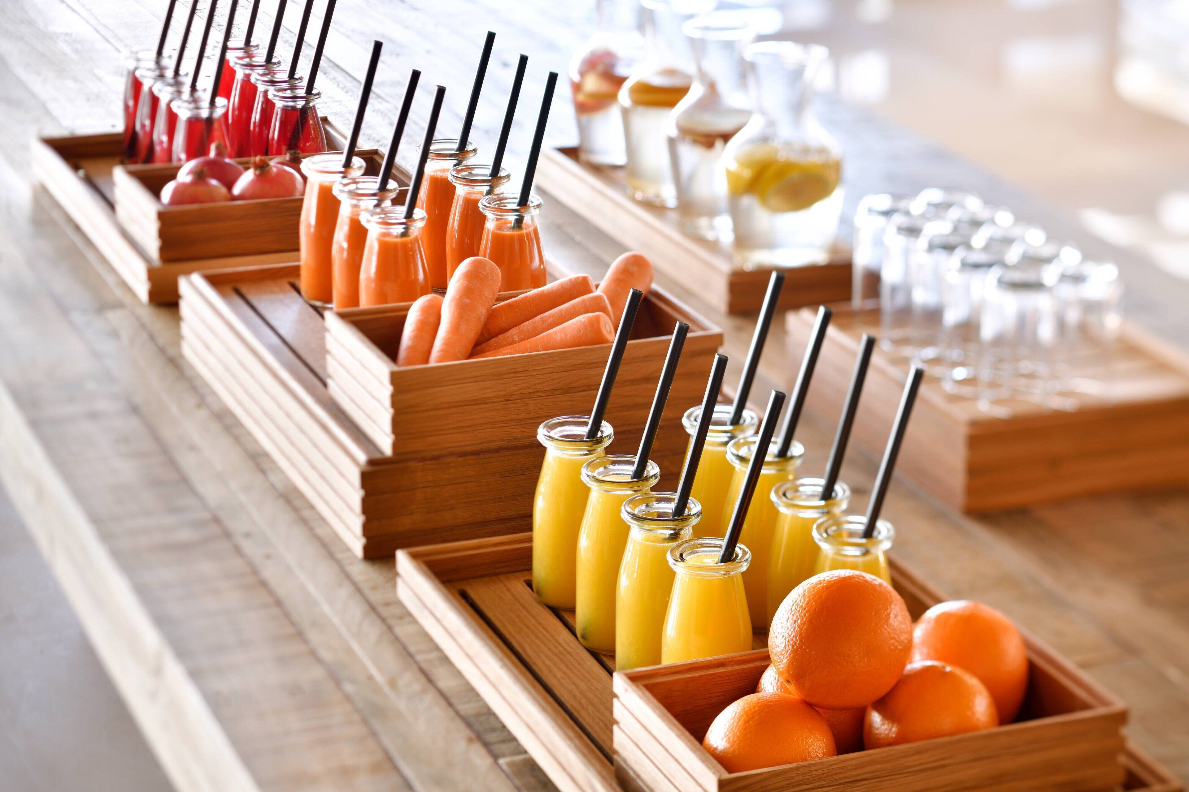 Un bufé con diversas opciones de comida y bebida, incluyendo jugos y frutas.
