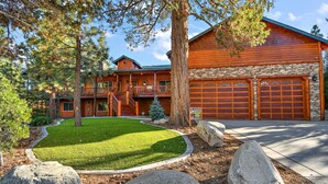 A log cabin with a stone foundation, a two-story structure, and a covered front porch.