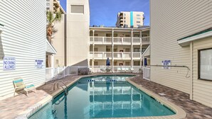 A swimming pool with a shallow water warning, no lifeguard on duty, and a 8 ft depth limit. - Steps to the beach  daily rentals pool washer dryer onsite two balconies full kitchen (Myrtle Beach)