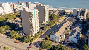 A coastal urban area with high-rise buildings, a beach, and a parking lot. - Steps to the beach  daily rentals pool washer dryer onsite two balconies full kitchen (Myrtle Beach)