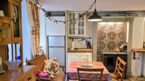 A cozy kitchen with a dining area, wooden furniture, a refrigerator, and a patterned backsplash. - HR Cottage am Honigbach in the center of Coesfeld (Coesfeld)