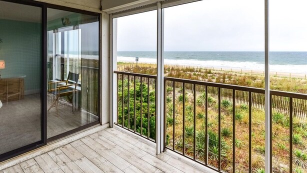 Un balcon avec vue sur la plage et l’océan.