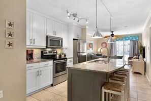 Enjoy cooking in this well-equipped kitchen with a central island, microwave, oven, and refrigerator.