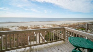 A wooden deck with a green bench overlooking a beach and boardwalk. - "Beach Time"  Oceanfront 3 bedroom 3 bath duplex (Holden Beach)